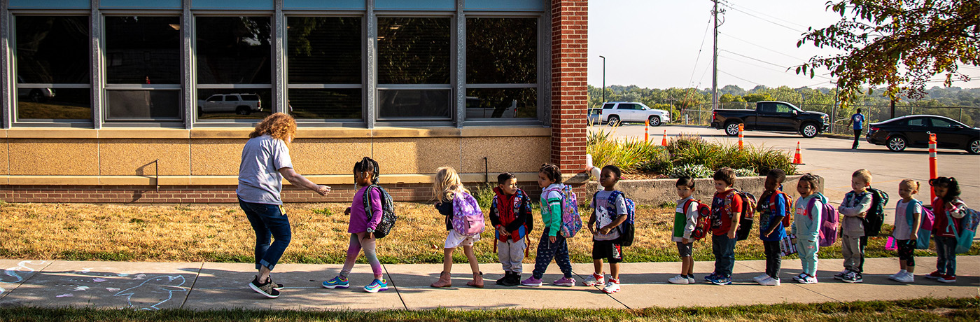 students walking in line in front of the school